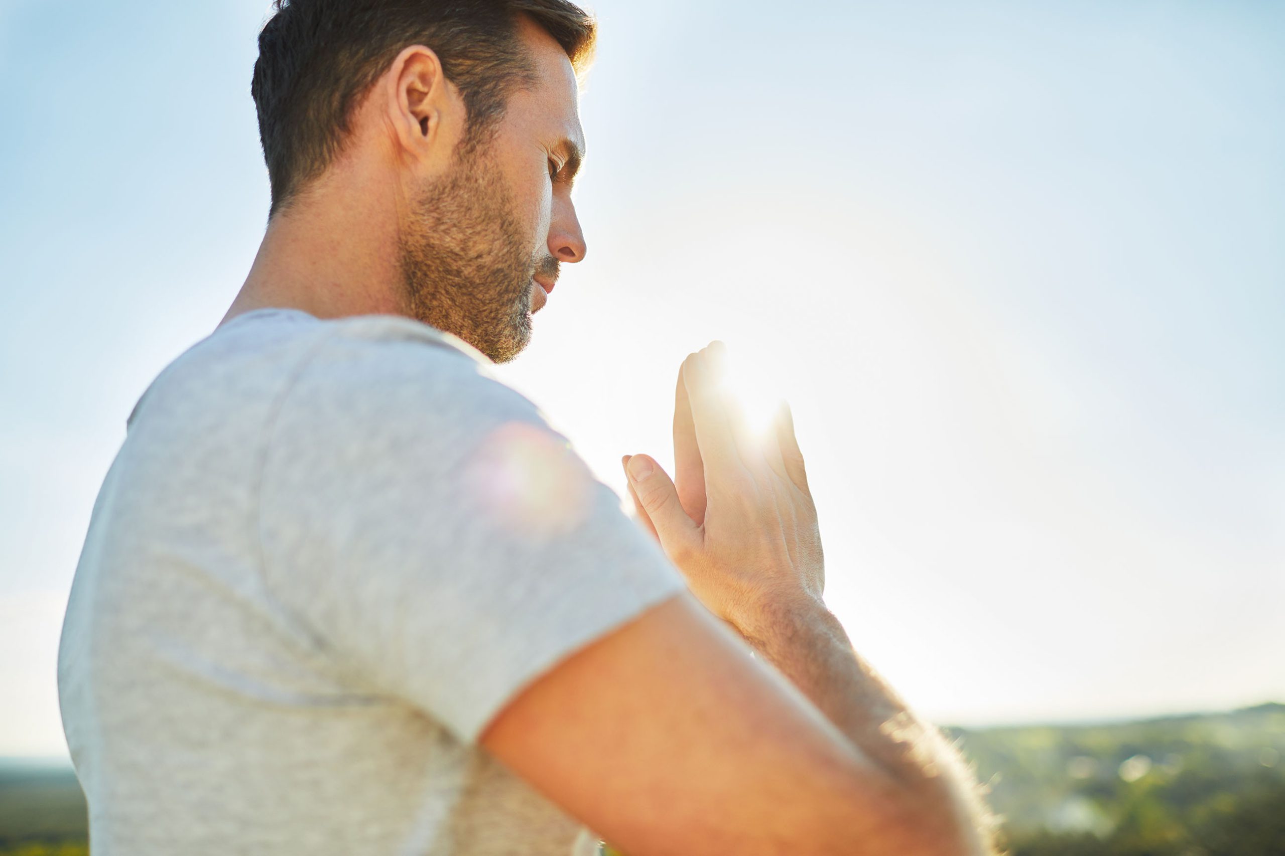 Adult man meditation outdoors with hands in prayer
